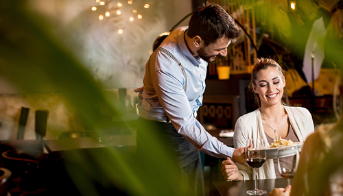 Tjener serverer mad for en person